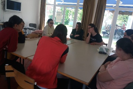 Slika nastala tokom osmog sastanka dok mentorica zajedno sa učesnicama sjedi za stolom 