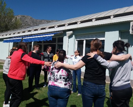 Slika nastala u dvorištu centra Los Rosales, dok ušesnice stoje poredane u krug i zagrljene dok se pripremaju za sportske aktivnosti.