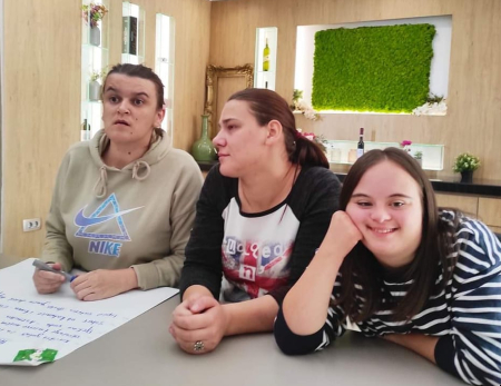 Na slici su tri djevojke od kojih je jedna djevojka sa Down sindromom. Slika je nastala tokom MyRight treniga za članice foruma žena s invaliditetom u Međugorju u oktobru 2022.