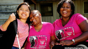 Slika. Mobility International USA Poziv za IX međunarodni Ženski institut za liderstvo i invaliditet (na slici su tri žene koje nose roze maice, prva sa lijeve strane drži bijeli štap)